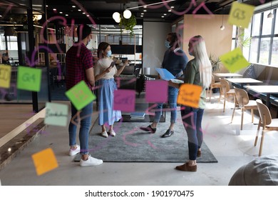 Diverse Group Of Business People Working In Creative Office. Group Of People Wearing Face Masks And Discussing Work. Social Distancing Protection Hygiene In Workplace During Covid 19 Pandemic.