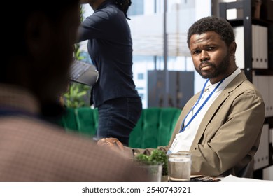 Diverse group of business professionals meeting to strategize on digital marketing initiatives, analyzing data infographics to work on global expansion. Staff ensuring organizational growth. - Powered by Shutterstock