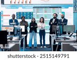 Diverse group of business professionals posing together in monitoring room, multinational company headquarters. Executive management team working with big data screen in the office.