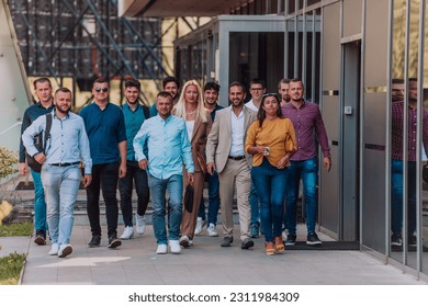 A diverse group of businessmen and colleagues walking together by their workplace, showcasing collaboration and teamwork in the company. - Shutterstock ID 2311984309