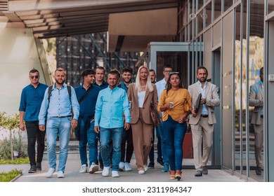 A diverse group of businessmen and colleagues walking together by their workplace, showcasing collaboration and teamwork in the company. - Shutterstock ID 2311984347