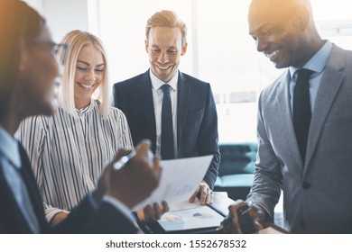 Diverse Group Of Businesspeople Smiling During A Meeting Together Around A Table In An Office