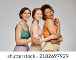 Diverse group of carefree real women wearing underwear and smiling happily against grey background, body positivity