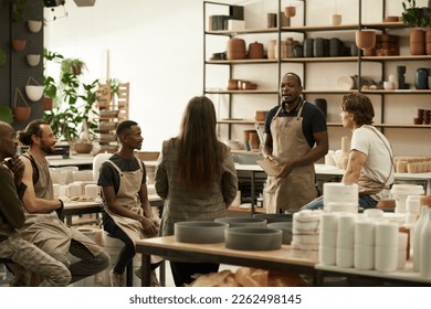 Diverse group of ceramics workers meeting together in a studio - Powered by Shutterstock