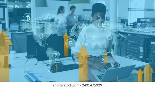 Diverse group of colleagues working in office, discussing cryptocurrency. asian woman wearing glasses, typing on laptop, african american colleague with a tablet, and biracial woman in background - Powered by Shutterstock