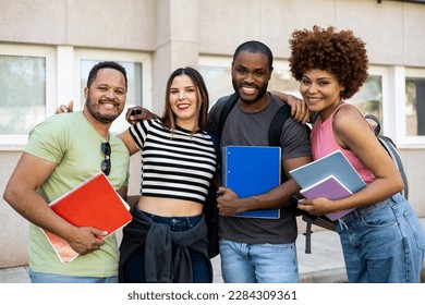 Diverse group of college students. Happy multi-ethnic young friends in casual clothes with backpacks, class textbooks posing the 4 guys holding on while looking at the camera outside. - Shutterstock ID 2284309361