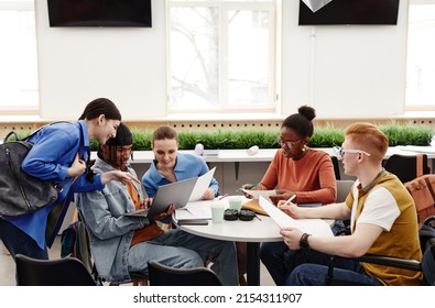 Diverse group of college students studying together at round table and discussing project, copy space - Powered by Shutterstock