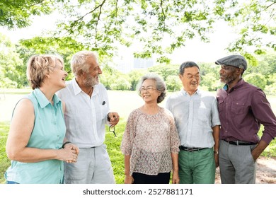 A diverse group of elderly friends, including men and women, enjoying a sunny day in the park. Elderly friends smiling, chatting, and enjoying the outdoors together. Happy elderly people, retirement. - Powered by Shutterstock