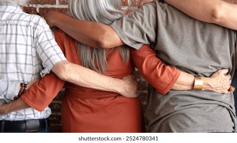 Diverse group of elderly people hugging, embracing each other. Elderly deivrse people showing unity and diversity. Elderly people hugging, diverse group, elderly people arms around each other - Powered by Shutterstock