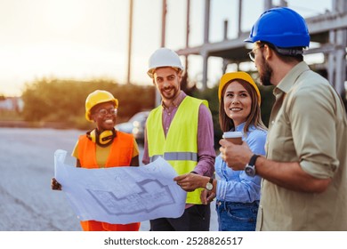 A diverse group of engineers in safety gear reviewing architectural plans at a construction site, promoting teamwork and collaboration in the building industry. - Powered by Shutterstock