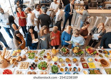 Diverse group enjoying a buffet with dishes. Men and women of different ethnicities socializing. Colorful food, lively atmosphere, and diverse crowd. Group of professional people at lunch buffet. - Powered by Shutterstock