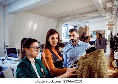 Diverse group of fashion designers reviewing the fabric in a design firm - Powered by Shutterstock