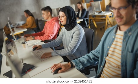 Diverse Group of Female and Male Students Sitting in College Room, Learning Computer Science. Young Scholars Study Information Technology on Computers in University, Getting Knowledgeable. Dutch Angle