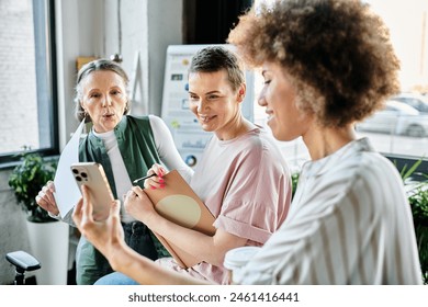 Diverse group of female professionals collaborating with a phone. - Powered by Shutterstock