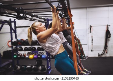 Diverse group of fit people in sportswear doing pullups using resistance bands during an exercise class at the gym - Powered by Shutterstock