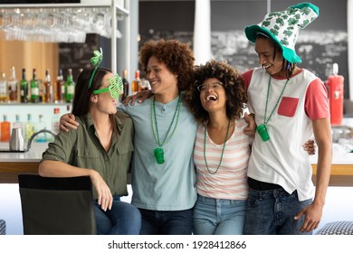 Diverse group of friends celebrating st patrick's day embracing and laughing at a bar. fun with friends during celebration of the irish patron saint's day. - Powered by Shutterstock