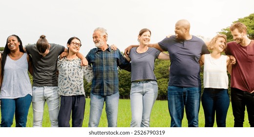 Diverse group of friends embracing park. Diverse group of men and women standing together huddle at park. Diverse group of friends, men and women, standing in row huddle on grass. Friends huddle - Powered by Shutterstock