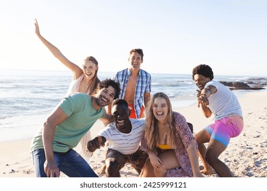 Diverse group of friends enjoy a day at the beach. Smiling and posing for a photo, they capture the essence of summer fun outdoors. - Powered by Shutterstock