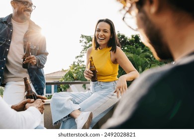 Diverse group of friends enjoying a sunny day outdoors, sharing drinks and laughter on a rooftop terrace. - Powered by Shutterstock