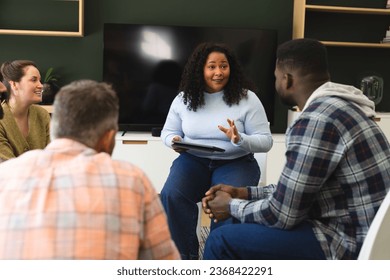 Diverse group of friends and female therapist with tablet in group therapy session. Mental health, therapy, friendship and support,communication, unaltered. - Powered by Shutterstock