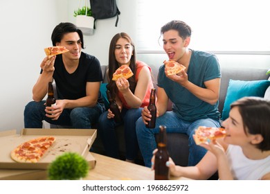 Diverse Group Of Friends Having Fun While Hanging Out In The Living Room. College Students Enjoying Dinner With Beer Together