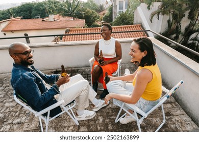 Diverse group of friends relaxing and having drinks, beer on a rooftop. Casual, outdoor setting with colleagues enjoying a fun, social gathering. - Powered by Shutterstock