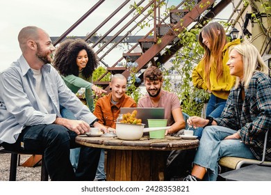 Diverse group of friends sharing ideas over coffee on a rooftop garden - Blending work and leisure in an urban setting - Powered by Shutterstock