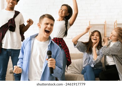 A diverse group of friends standing together on a stage, singing into a microphone, dressed in casual clothing and are passionately performing for an audience - Powered by Shutterstock