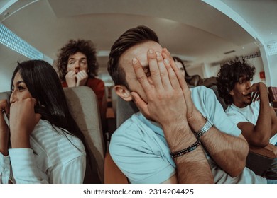A diverse group of friends with terrified expressions together in a cinema to watch a horror film, experiencing a mix of fear, excitement, and laughter, as they collectively navigate through