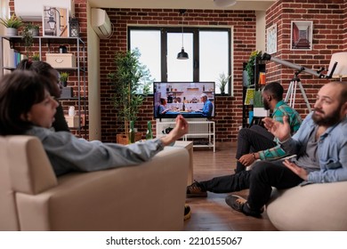 Diverse Group Of Friends Watching Movie On Television Together At House Party, Looking At People On Tv Show. Men And Women Drinking Beer And Enjoying Film On Drama Channel Program.