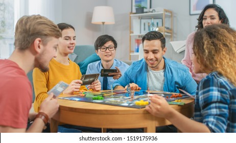 Diverse Group of Guys and Girls Playing in a Strategic Board Game with Cards and Dice. Cozy Living Room in a Daytime
