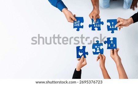 A diverse group of hands engaging in assembling blue puzzle pieces, symbolizing collaboration and teamwork in achieving business goals and innovative solutions. Amity