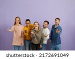 Diverse group of happy cheerful young multiethnic people standing together, looking at the camera, smiling, extending their hands and doing an inviting gesture, telling you 