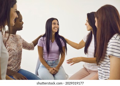 Diverse group of happy cheerful young women sitting in circle, talking and supporting their friend. Positive good looking ladies sharing news, giving each other advice and having nice time together