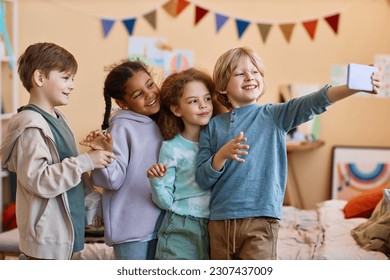 Diverse group of happy children taking selfie photo together and smiling - Powered by Shutterstock