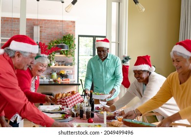 Diverse group of happy senior friends in holiday hats celebrating christmas together at home. christmas festivities, celebrating at home with friends. - Powered by Shutterstock