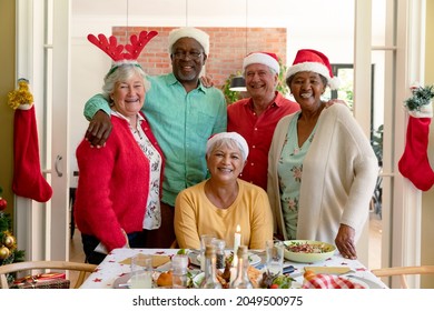 Diverse Group Of Happy Senior Friends In Holiday Hats Celebrating Christmas Together, Taking Photo. Christmas Festivities, Celebrating At Home With Friends.