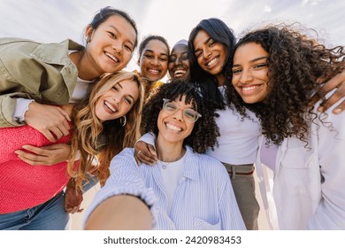 Diverse group of happy young female friends having fun taking selfie portrait together outdoors. Female friendship and youth concept. - Powered by Shutterstock