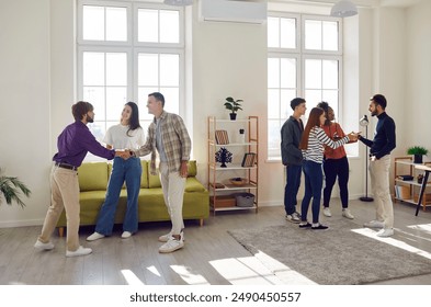 Diverse group of happy young men and women, friends and students talking on home party in the living room. Lively conversations fill the air, energetic team enjoys the company. - Powered by Shutterstock