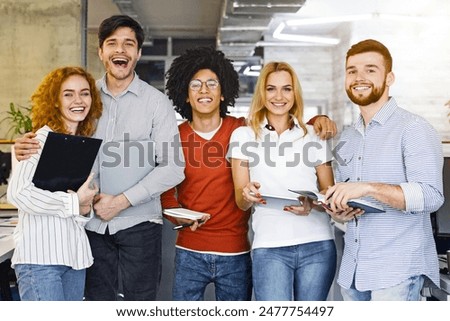 A diverse group of individuals standing closely next to each other in a row, looking towards the camera. They appear to be engaged in a conversation or event, showing unity and togetherness.