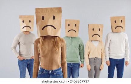 Diverse group of individuals wearing paper bags with drawn sad faces on heads, creating a unique and thought provoking portrait that reflects a shared sense of emotion and solidarity. - Powered by Shutterstock