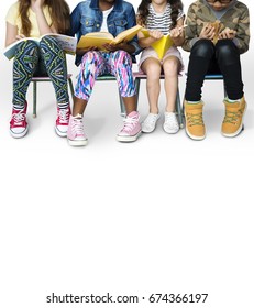 Diverse Group Of Kids Sitting In A Row Reading Books