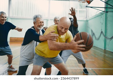 Diverse group of male seniors playing basketball in an indoor basketball gym - Powered by Shutterstock