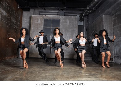 Diverse group of multiethnic dancers or performers showcase talent on stage in a contemporary dance show, dressed in black costumes. - Powered by Shutterstock