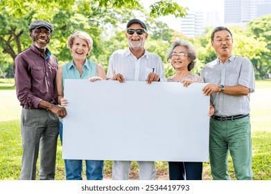 Diverse group of older adults holding a blank sign outdoors. Smiling seniors, men and women, enjoying a sunny day in the park. Diverse, happy seniors gathering in the park holding blank sign. - Powered by Shutterstock