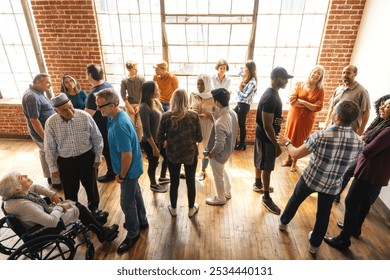 Diverse group of people in a bright room, engaging in conversation. Men and women of various ethnicities, standing and interacting, creating a lively atmosphere. Diverse crowd mingle at social event. - Powered by Shutterstock