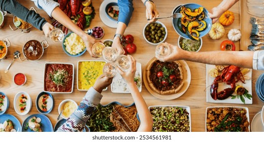 A diverse group of people enjoying a festive meal, sharing food and drinks. Top view of a table with various dishes, celebrating togetherness and diversity. Diverse people celebrating and toasting. - Powered by Shutterstock