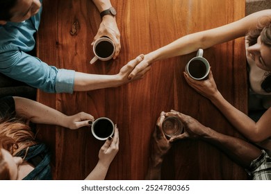 Diverse group of people having coffee. Top view of hands holding coffee cups. Coffee meeting with diverse hands. Diverse group of people making business deal. Diverse people drinking coffee - Powered by Shutterstock