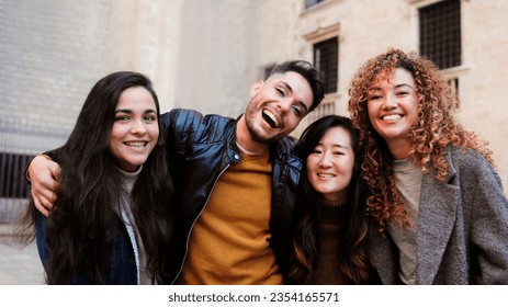 Diverse group of people having fun together outside - Happy friends of different ethnicity looking at camera - Focus on gay non-binary person - Shutterstock ID 2354165571
