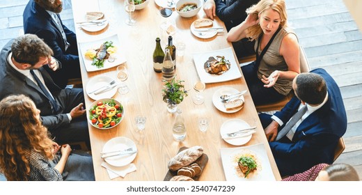 A diverse group of people, including men and women, enjoying a gourmet meal at a long table. The elegant dining setting features delicious dishes, wine, and lively conversation. - Powered by Shutterstock